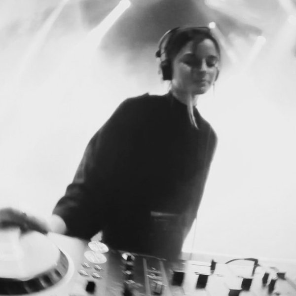 Marise draait achter de decks, in zwart-wit